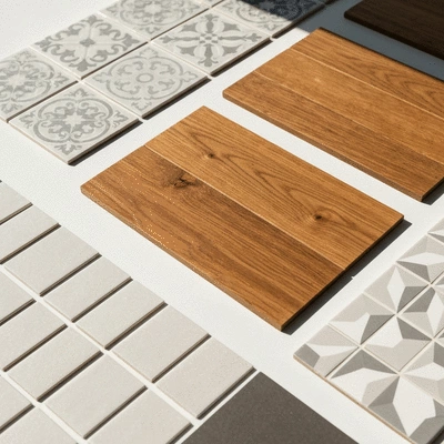 Various kitchen backsplash material samples laid out, including tile, peel-and-stick, and wood panels